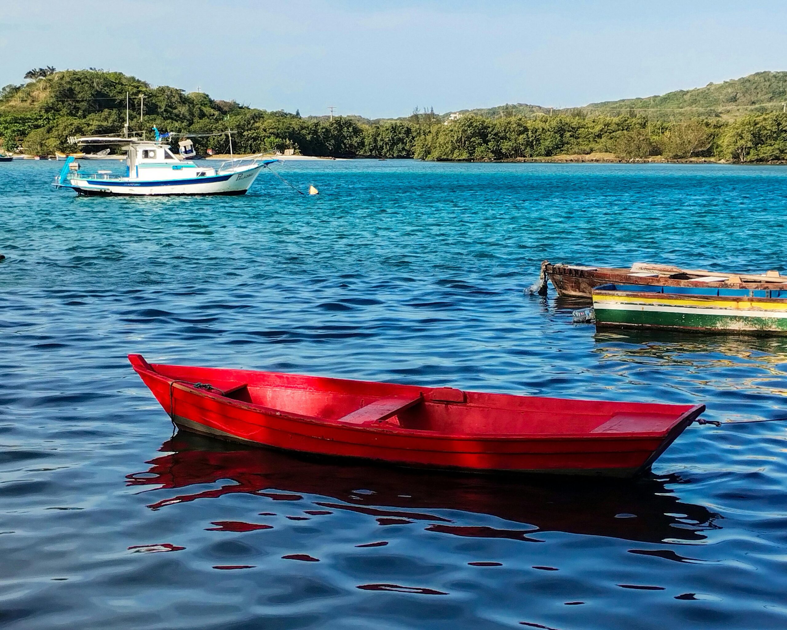 A vibrant photo of colorful boats floating on blue waters in Cabo Frio, Brazil.